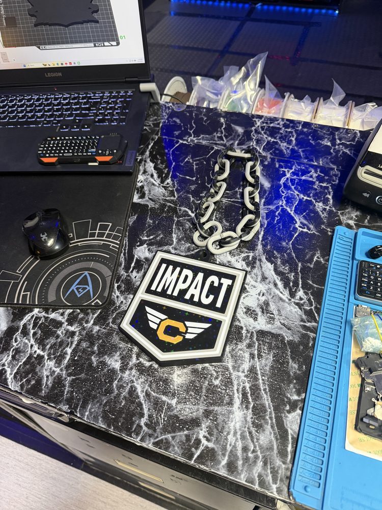 Black and white Impact badge on a printed chain