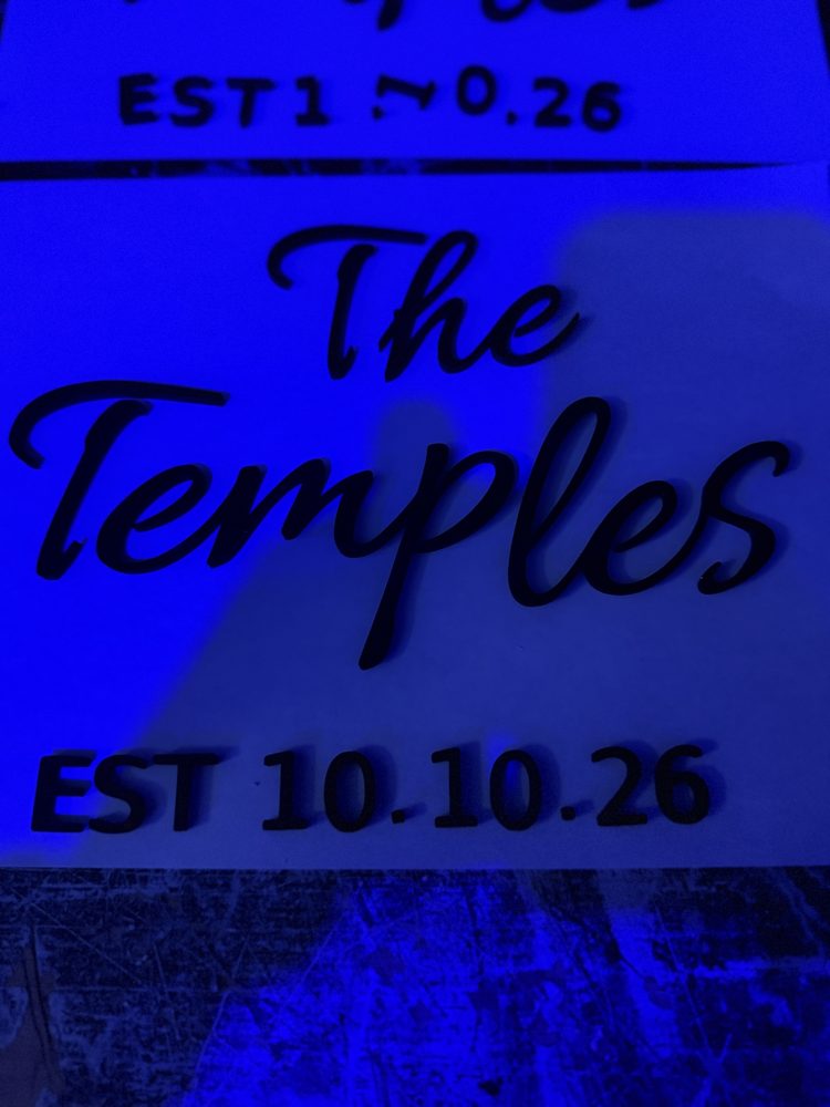 3D-printed The Temples EST 10.10.26 sign under blue light